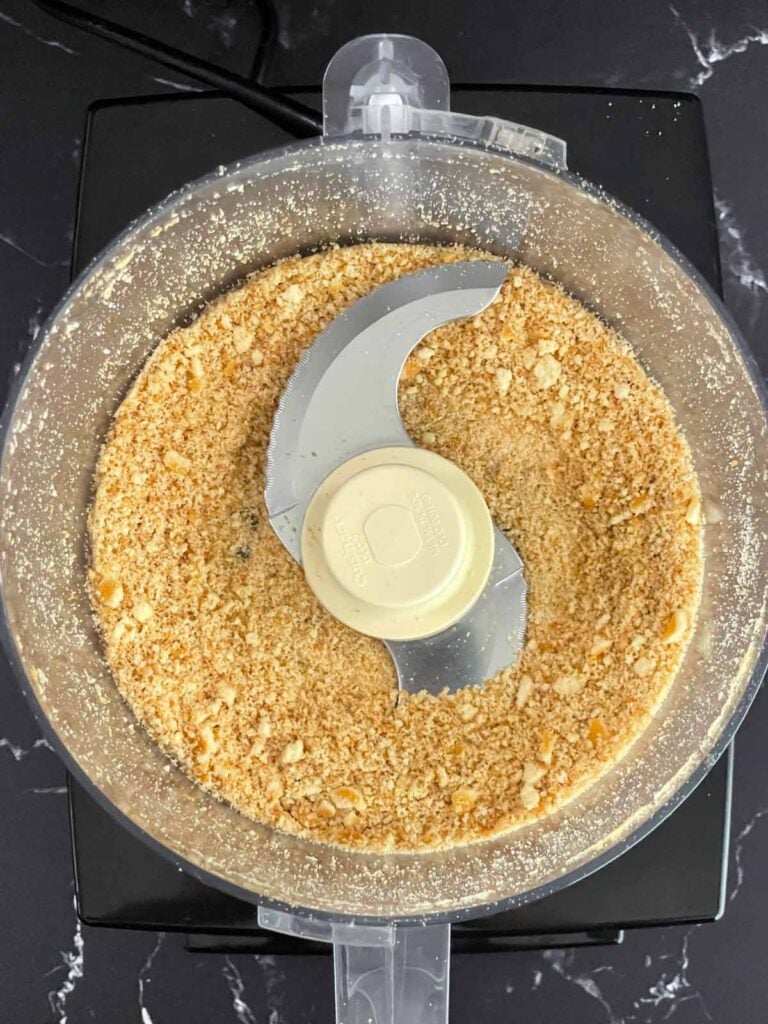 Vanilla wafers crushed in the bowl of a food processor.