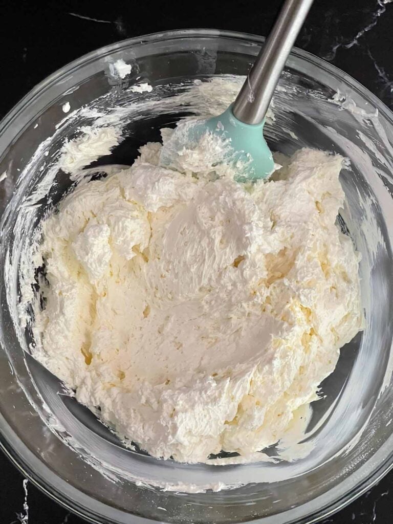 Cream cheese layer ingredients combined in a glass bowl.