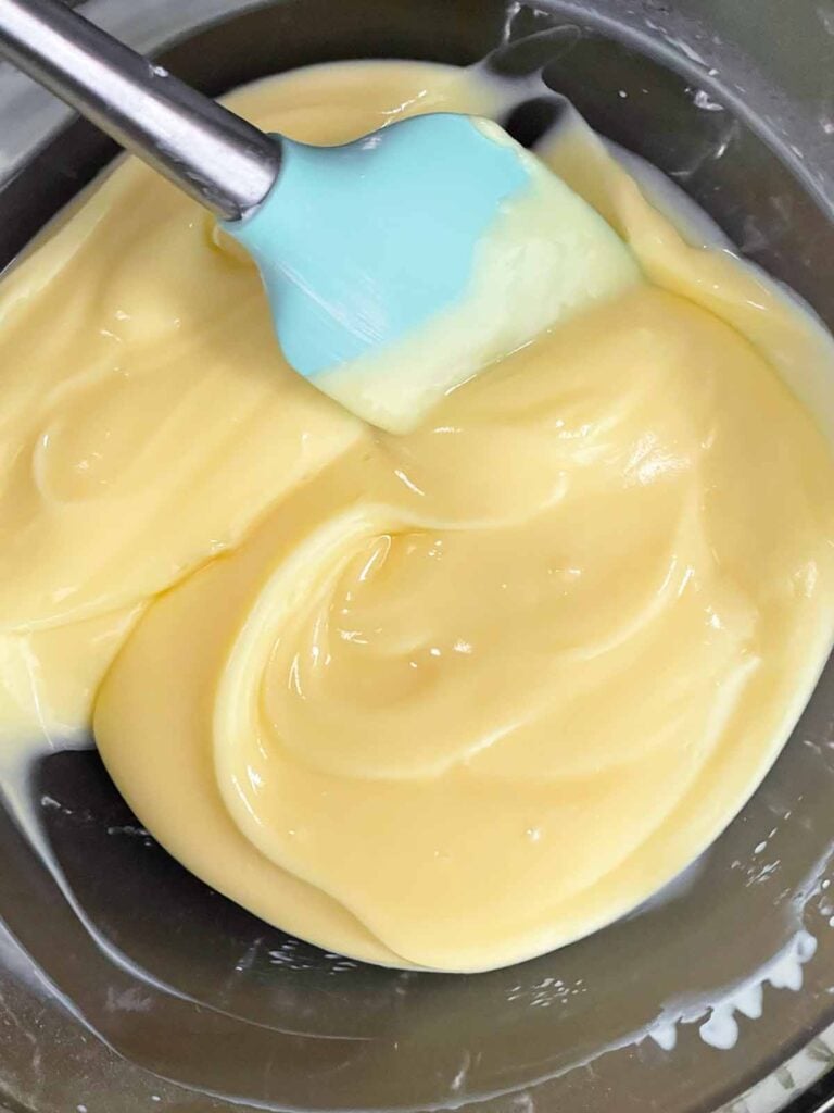 Banana pudding thickening up in a glass bowl.