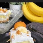 A slice of banana pudding lush on a dark plate garnished with crushed vanilla wafers.
