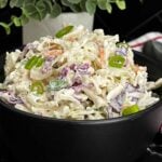Bowl of Classic Coleslaw with crisp cabbage, carrots, and green onions in a creamy homemade dressing.