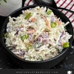 Bowl of Classic Coleslaw with crisp cabbage, carrots, and green onions in a creamy homemade dressing.