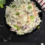 Creamy Classic Coleslaw in a black serving bowl made with coleslaw mix, green onions, and a tangy dill pickle dressing.