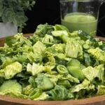 Green Goddess Salad in a wooden bowl with Napa cabbage, spinach, arugula, cucumbers, snow peas, and creamy herb dressing.