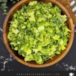 Green Goddess Salad in a wooden bowl with Napa cabbage, spinach, arugula, cucumbers, snow peas, and creamy herb dressing.