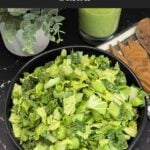 Green Goddess Salad in a black bowl with Napa cabbage, spinach, arugula, cucumbers, snow peas, and creamy herb dressing.