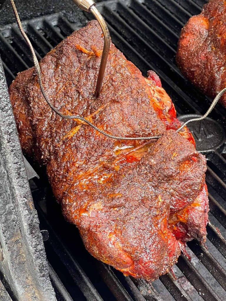 Close-up of smoked boneless pork butt with a deep mahogany bark forming.