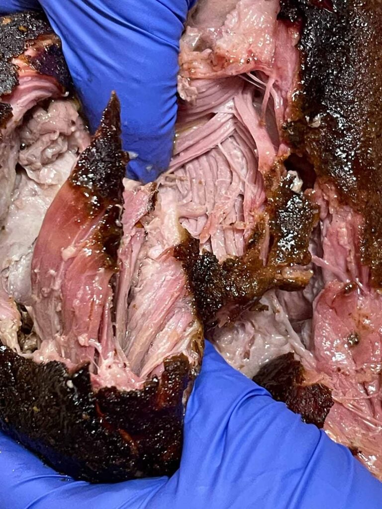 Tearing up the smoked pork butt with gloved hands