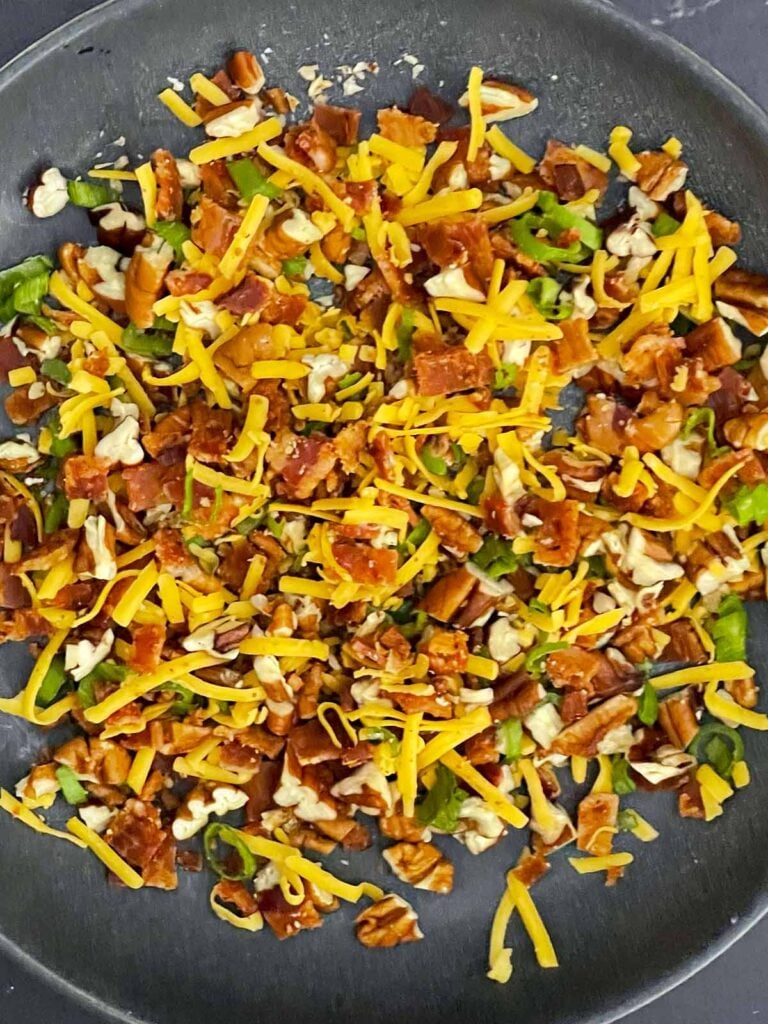 Chopped bacon, pecans, green onions, and shredded cheddar combined for the cheese ball coating.