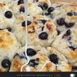 Vanilla glaze drizzled over warm blueberry biscuits.