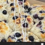 Vanilla glaze drizzled over warm blueberry biscuits.