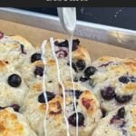 Vanilla glaze drizzled over warm blueberry biscuits.