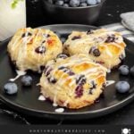 Flaky blueberry biscuits with vanilla glaze and fresh blueberries inside.