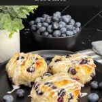 Flaky blueberry biscuits with vanilla glaze and fresh blueberries inside.