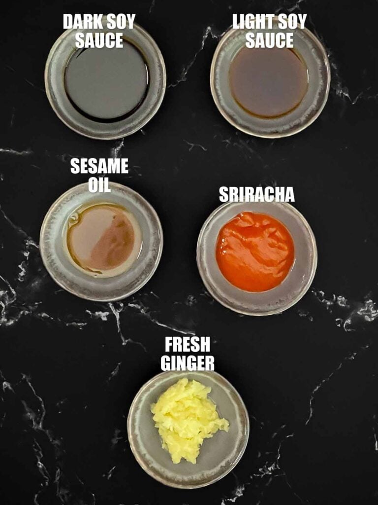 Ingredients for the homemade brown fried rice sauce including soy sauce, sweet soy sauce, Sriracha, sesame oil, and fresh ginger in small ramekins.