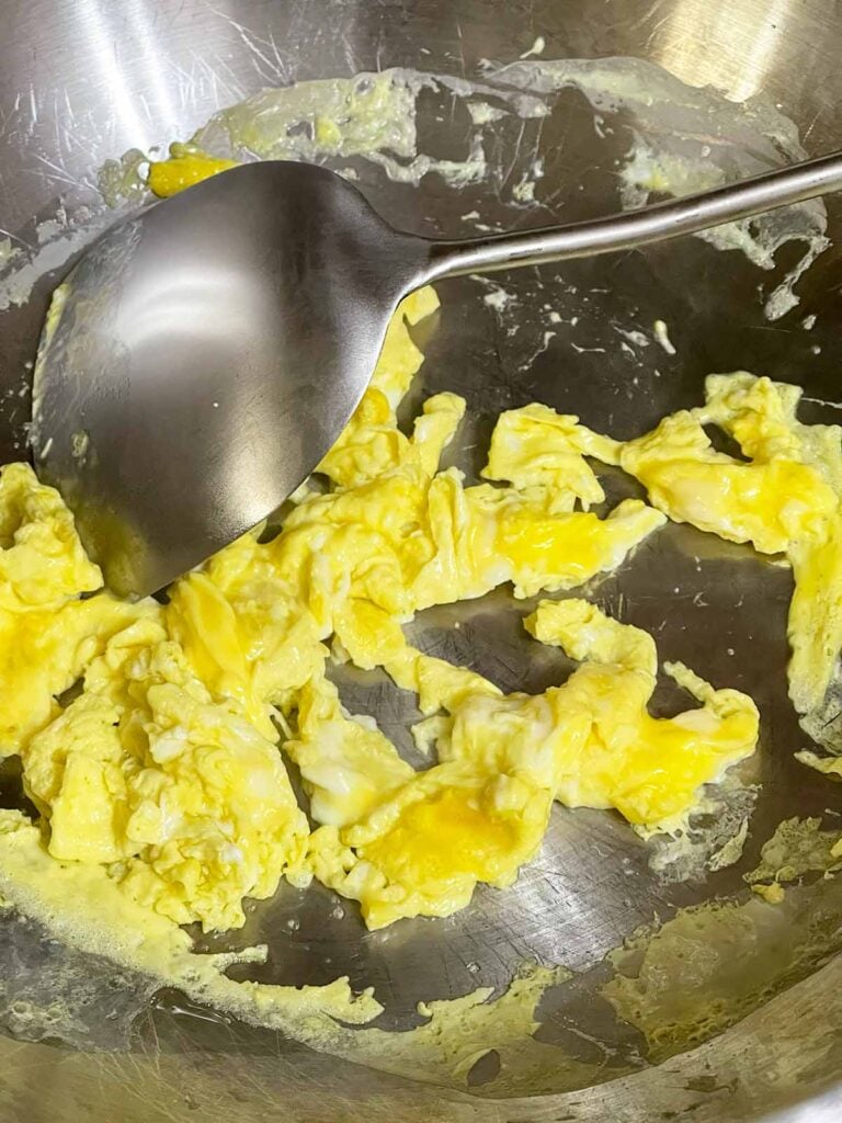 Soft scrambled eggs cooked in a wok before being added back to the fried rice.