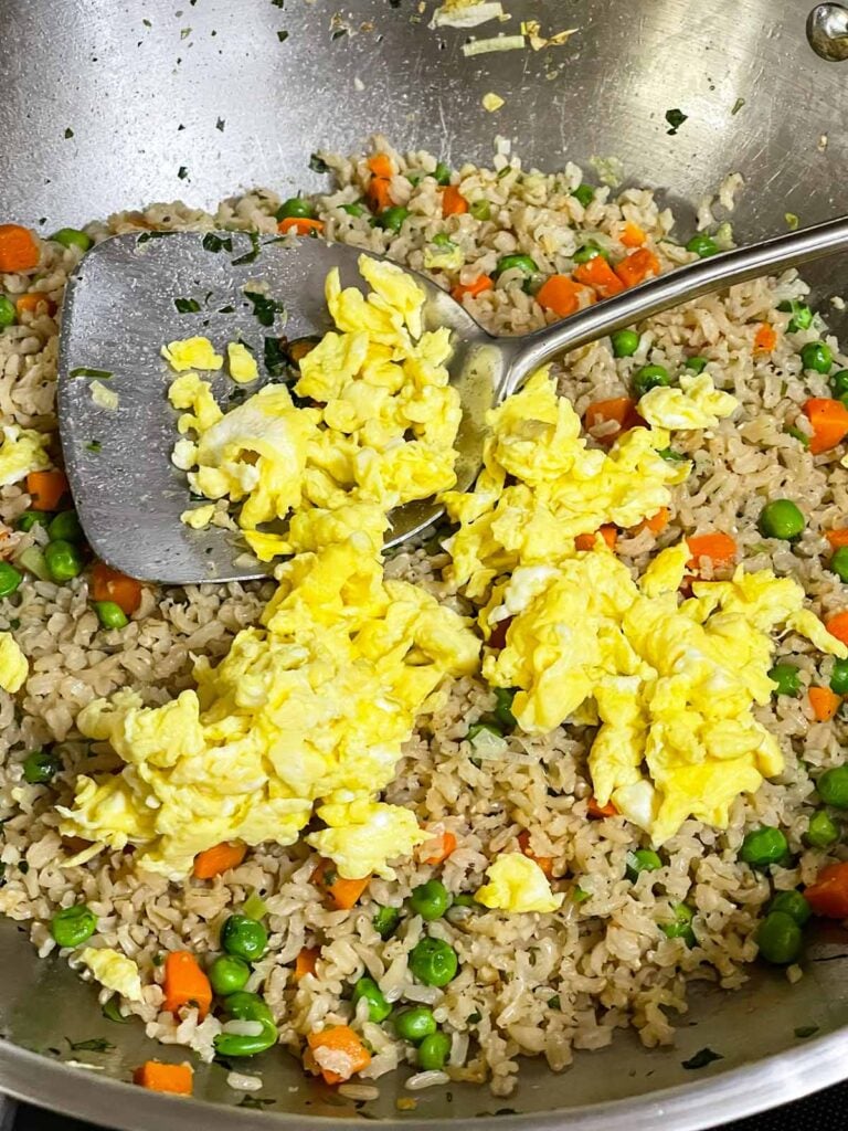 Scrambled eggs added back to the wok with the brown rice and vegetables.