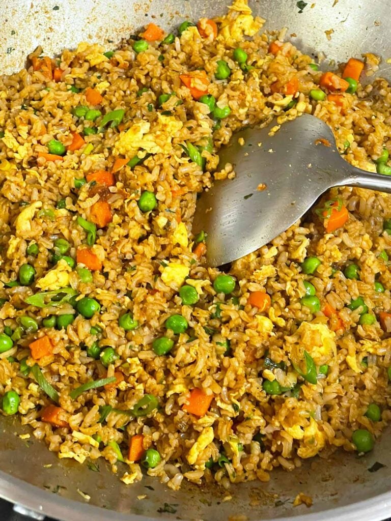 Brown fried rice tossed with fresh green onions and ready to serve.