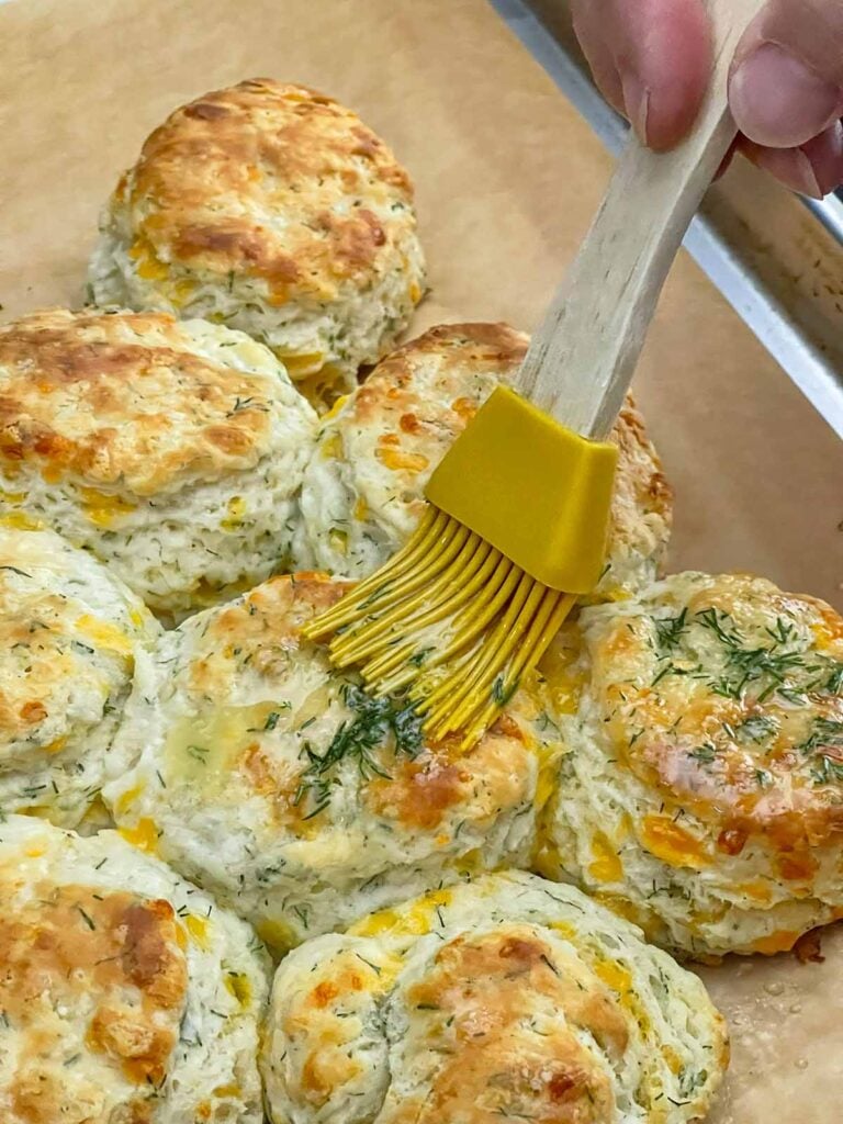 Freshly baked cheddar dill biscuits brushed with garlic dill butter while still warm.