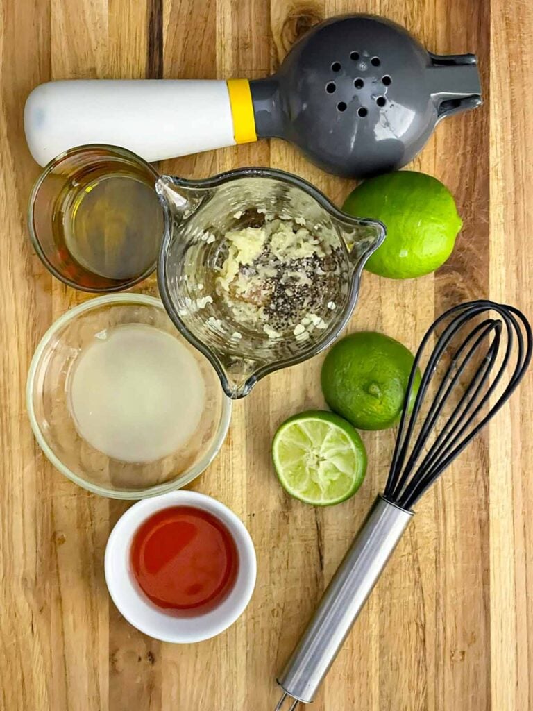 Olive oil, lime juice, red wine vinegar, honey, garlic, salt, and pepper in a measuring cup before mixing the Cowboy Caviar dressing.