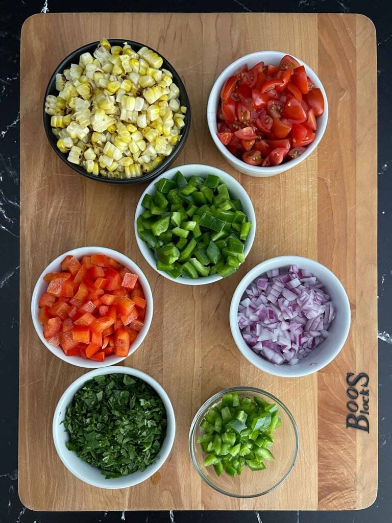 Chopped tomatoes, bell peppers, jalapeño, red onion, and cilantro prepared for Cowboy Caviar.