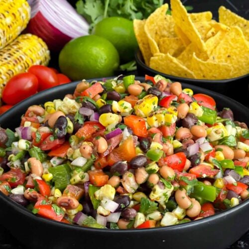 Easy Cowboy Caviar made with black beans, black-eyed peas, corn, tomatoes, peppers, and cilantro in a serving bowl.