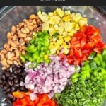 Fresh vegetables, beans, and corn tossed together in a large bowl before adding the dressing for Cowboy Caviar.
