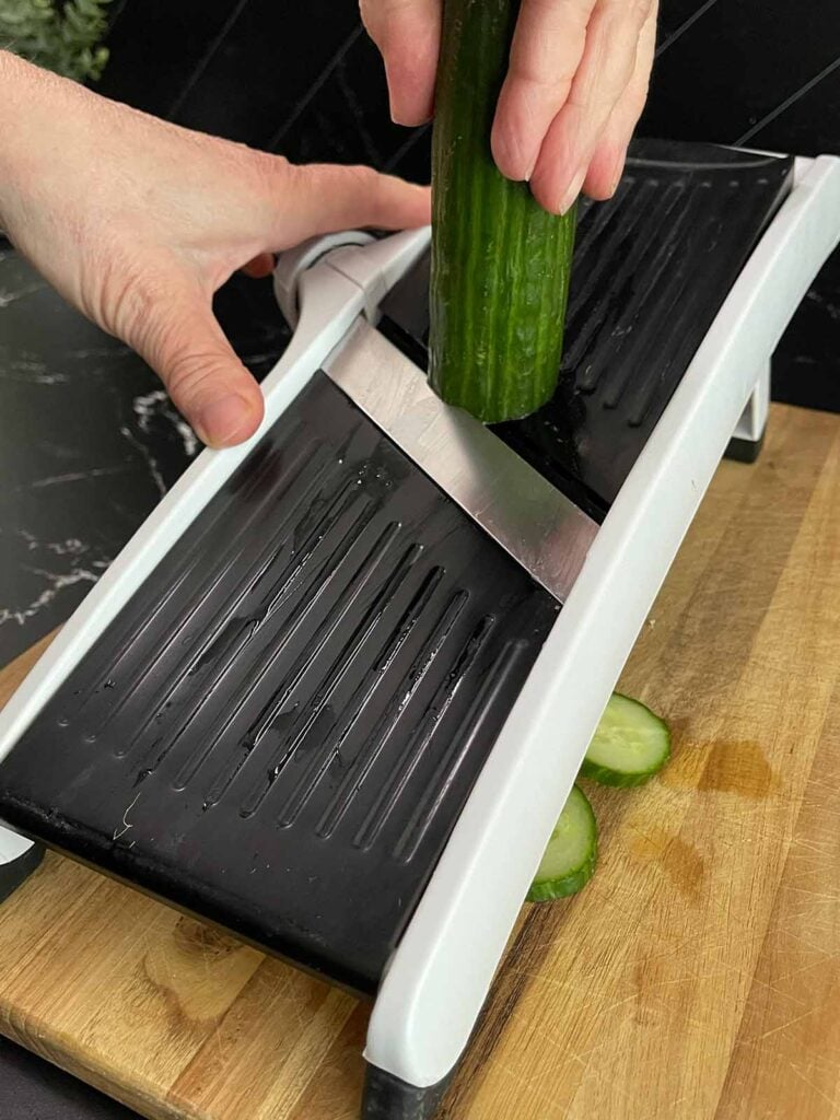 Thinly slicing English cucumbers for creamy cucumber salad.
