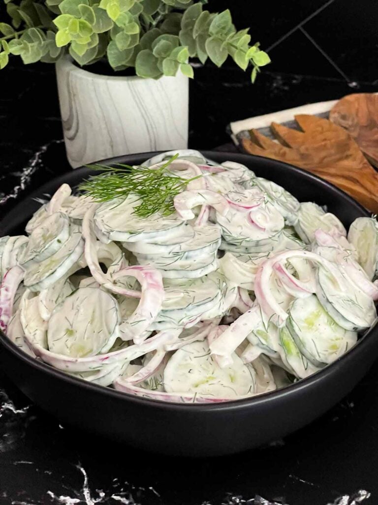 Creamy cucumber salad with fresh dill and red onion ready to serve.