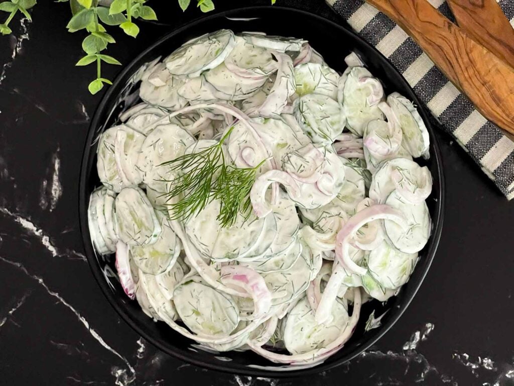 Creamy cucumber salad with fresh dill and red onion ready to serve.