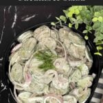 Creamy cucumber salad with fresh dill and red onion ready to serve.