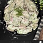 Creamy cucumber salad with fresh dill and red onion ready to serve.