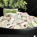Creamy cucumber salad with fresh dill and red onion ready to serve.