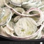Close-up of creamy cucumber salad made with English cucumbers, fresh dill, and sour cream dressing.