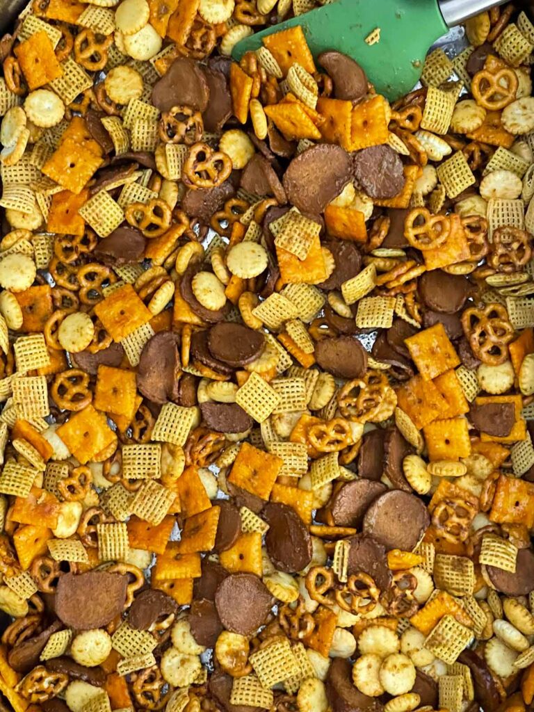 Old Bay Snack Mix spread into an even layer in a roasting pan before baking.