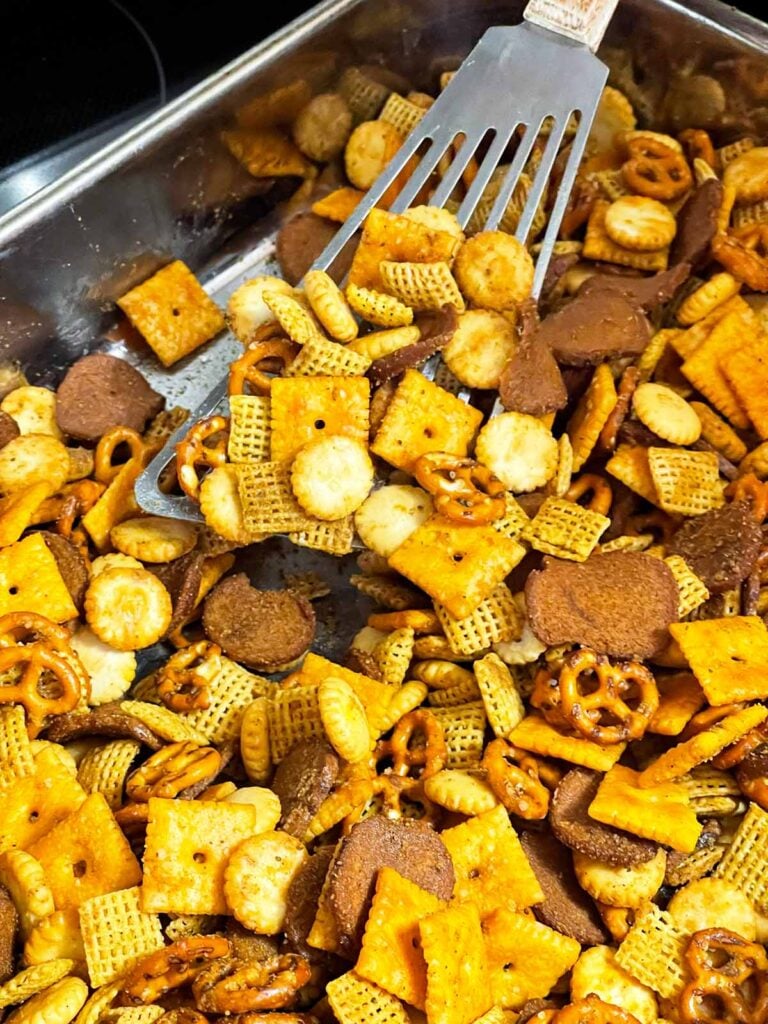 Old Bay Snack Mix stirred halfway through baking for even toasting and seasoning.