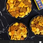Overhead view of homemade Old Bay Snack Mix in a serving bowl on a wooden table.