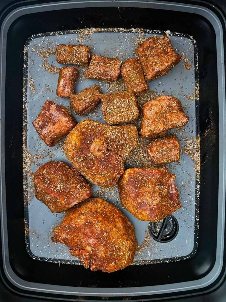 Raw oxtail with a rub applied in a tub.
