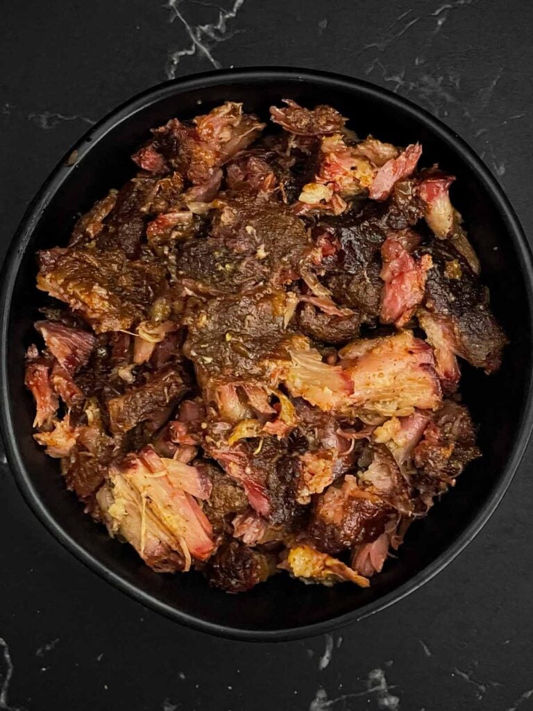 Smoked oxtail meat deboned in a dark bowl.