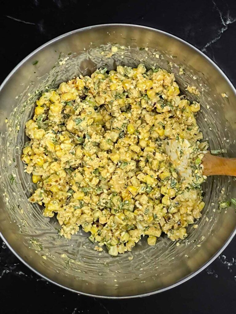 Roasted corn relish in a stainless steel bowl.