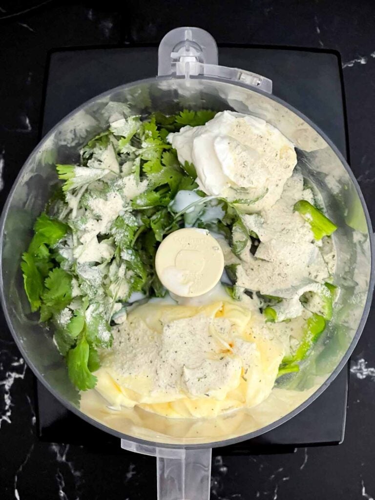 Ingredients for jalapeno cilantro sauce in a food processor.