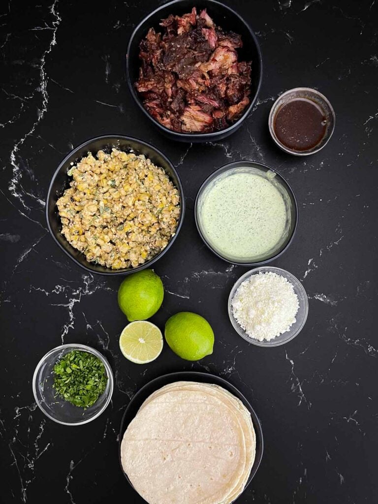 All the components to make a smoked oxtail taco on a dark background.