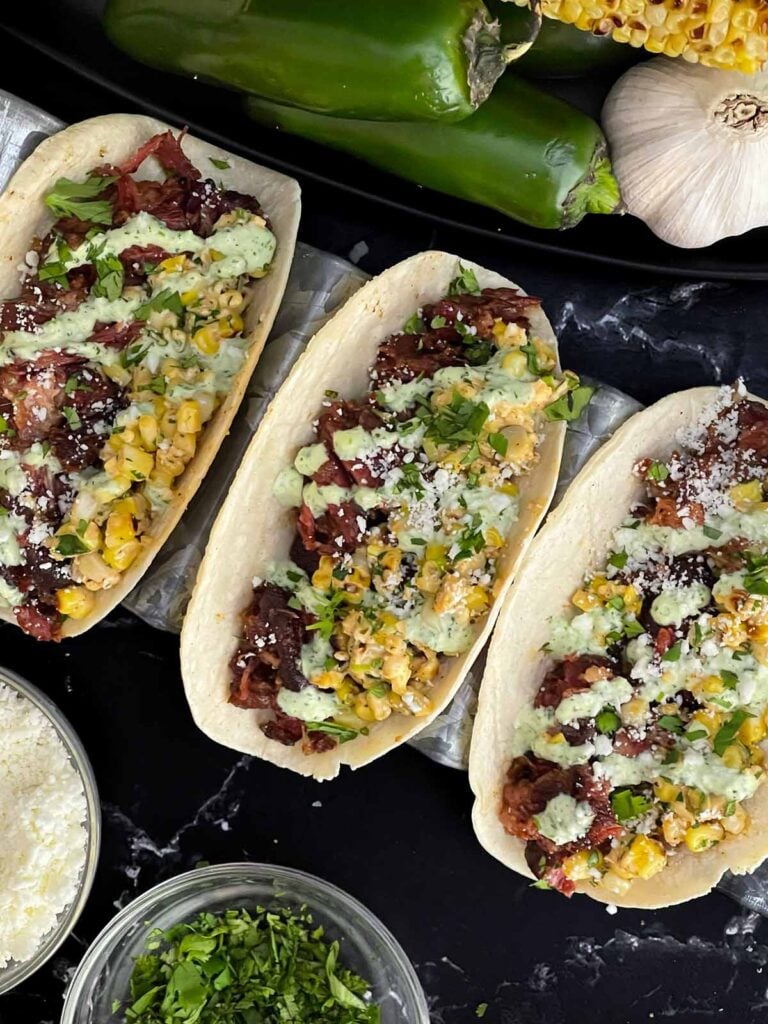 Smoked Oxtail with a roasted corn relish. Condiments are in the background.