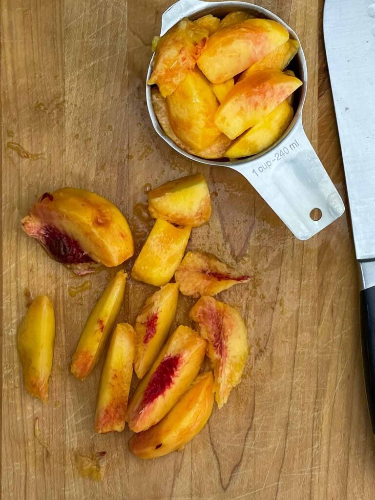 Fresh peaches cut into thick slices and chunks for old fashioned peach cobbler.