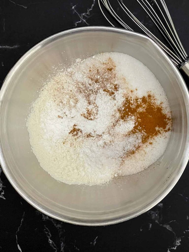 Dry ingredients in a metal bowl for the peach cobbler batter.