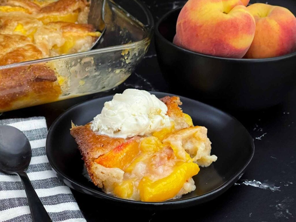 Close-up of homemade peach cobbler showing juicy peaches and a buttery golden crust.