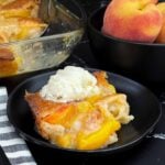 Close-up of homemade peach cobbler showing juicy peaches and a buttery golden crust.