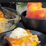 Warm serving of old-fashioned peach cobbler topped with a scoop of vanilla ice cream.