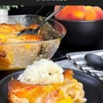 Warm serving of old-fashioned peach cobbler topped with a scoop of vanilla ice cream.