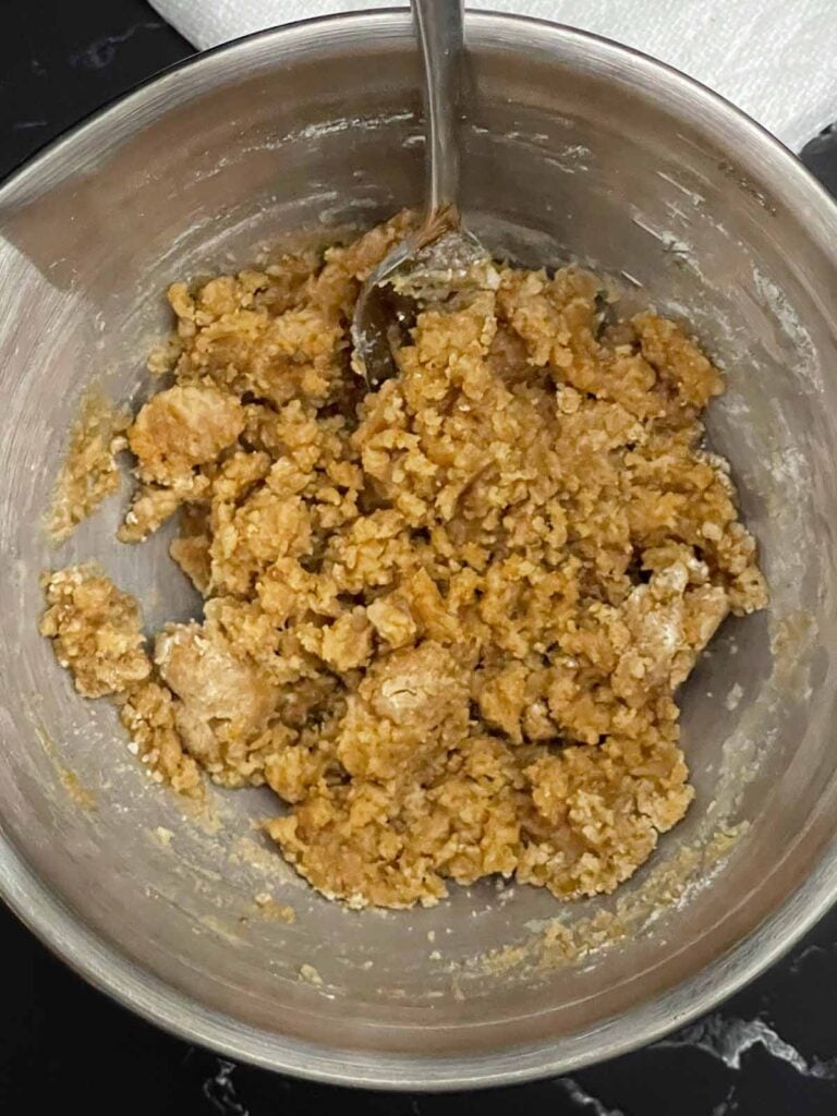 Butter mixed into the streusel topping for homemade peach muffins.